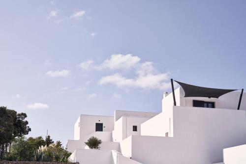 a white building with a blue sky in the background at Liostasi in Ios Chora