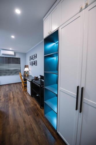 an office with a desk and a closet with blue shelves at Cribs - homestay in West Lake in Hanoi