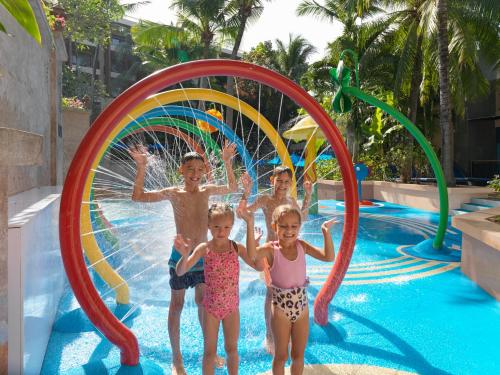 un gruppo di bambini che giocano in acqua in piscina di Novotel Phuket Kata Avista Resort and Spa a Kata Beach