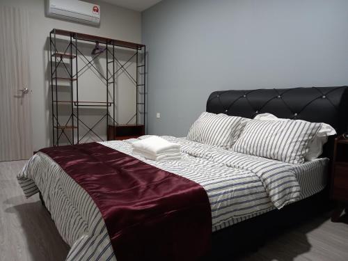 a bedroom with a large bed with a black headboard at KAN JIA in Miri