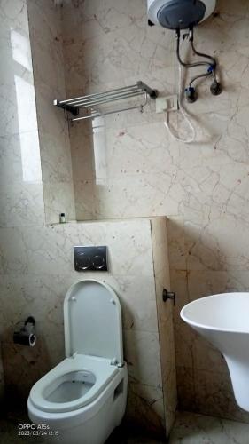 a bathroom with a toilet and a sink at Hotel Rivasa Regency in New Delhi