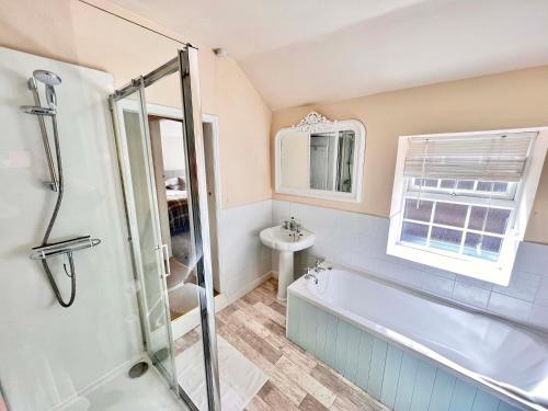 a bathroom with a bath tub and a sink at Gate Cottage in Matlock