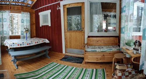 a room with a red house with a door and a rug at Punainen tupa in Kalajoki