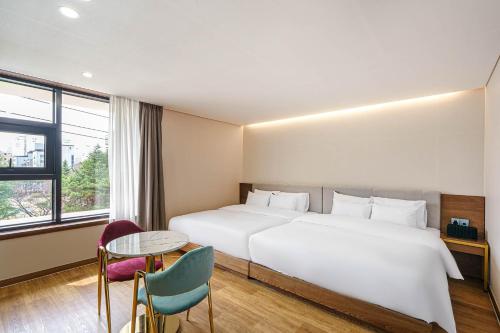 um quarto de hotel com uma cama grande e uma mesa em Browndot Hotel Jeonju Ajung em Jeonju