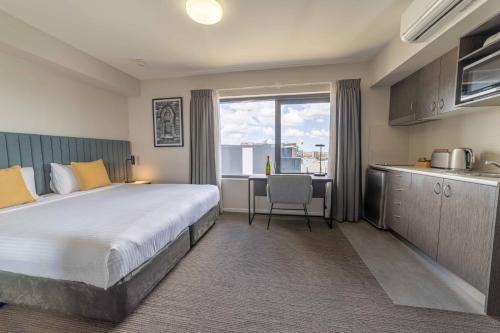 a hotel room with a large bed and a kitchen at Quest Rockhampton in Rockhampton