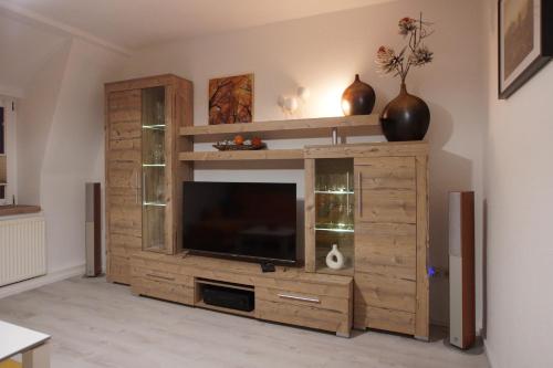 a large wooden entertainment center with a flat screen tv at Ferienwohnung Ostard 2 in Thale