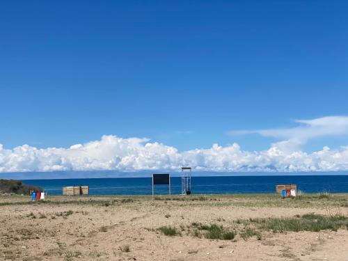 a beach with a sign in the middle of the ocean at Yurt camp Sonun in Bokonbayevo