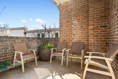 a group of chairs sitting on a patio at Discover The Rocks - Historical Terrace House in Sydney
