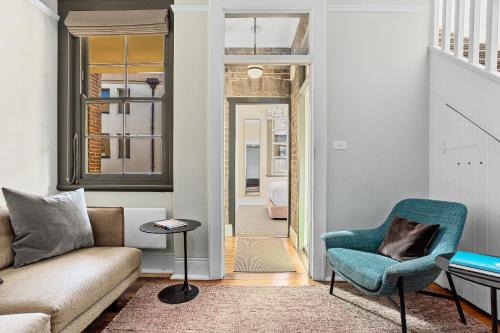 a living room with a couch and a chair at Discover The Rocks - Historical Terrace House in Sydney