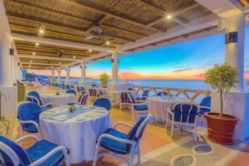 a restaurant with tables and chairs and a view of the ocean at Pueblo Bonito Los Cabos Blanco Beach Resort - All Inclusive in Cabo San Lucas