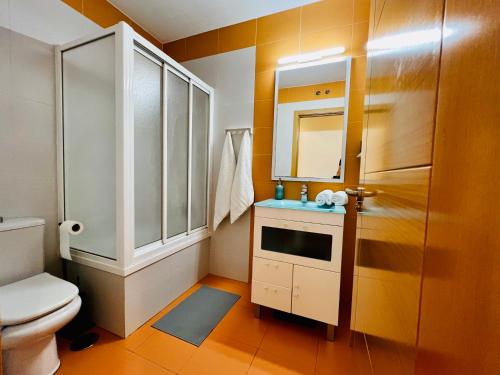a bathroom with a toilet and a sink and a mirror at La Latina Premium Home in Madrid