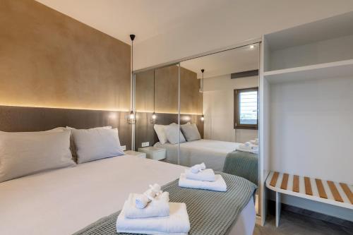 una camera d'albergo con due letti e uno specchio di Ostrako Luxury Villa 