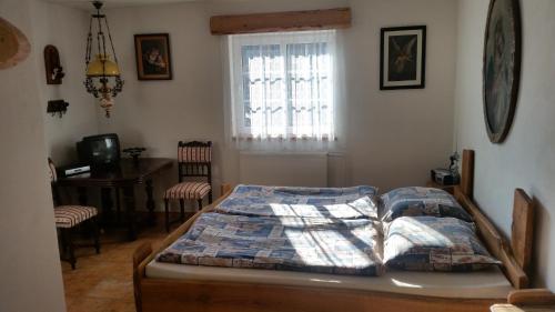 a bedroom with a bed and a table and a window at Chata Hadov in Klášterec nad Ohří