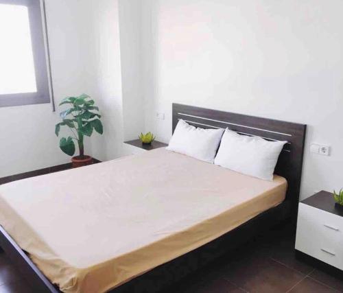 ein Schlafzimmer mit einem großen Bett mit weißer Bettwäsche und Kissen in der Unterkunft Apartamento en el Corazon del Delta in Sant Jaume d’Enveja