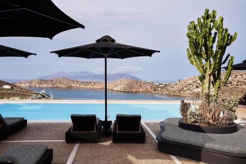 a pool with two chairs and an umbrella at Liostasi in Ios Chora