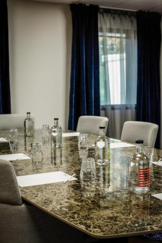 a table with glasses and bottles on top of it at Best Western Plus Le Conquerant Rouen Nord in Bois-Guillaume