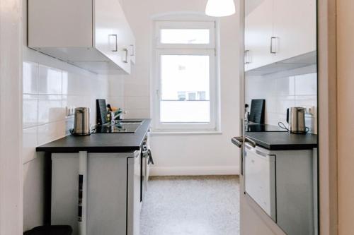 a kitchen with black counter tops and a window at Zentral und frisch eingerichtet: 2 Zi. 24h Checkin in Kiel