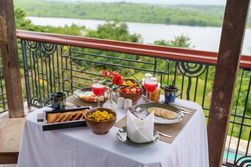 Una mesa con comida y bebidas en un balcón. en ama Stays & Trails L'Attitude By The Lake, Kamshet, Pune, en Khamshet