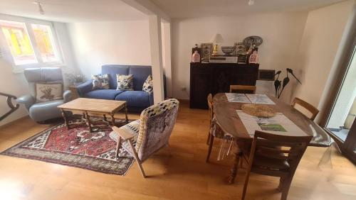 a living room with a table and a blue couch at le bonheur est parfois cache dans l'inconnu in Sélestat