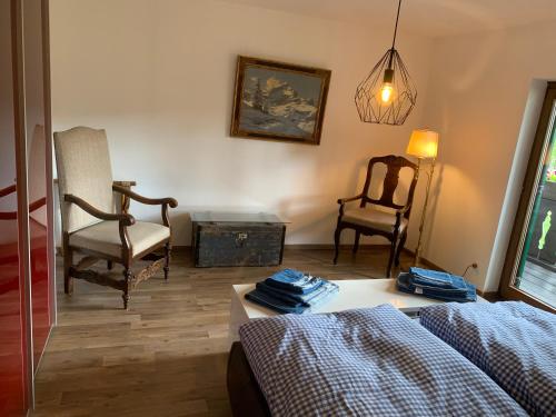 a bedroom with a bed and a chair and a table at Haus Fremerey in Krün