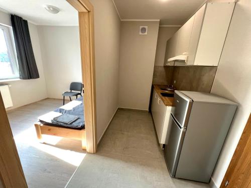 eine kleine Küche mit einem Kühlschrank und einem Tisch in der Unterkunft OSPER Rooms in Łomża