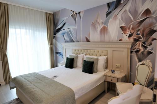 a bedroom with a bed with a flower mural on the wall at Park Luxury Rooms in Predeal