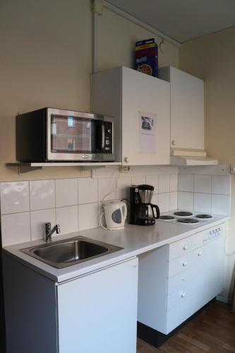 a kitchen with a sink and a microwave at Hotell Drott in Norrköping