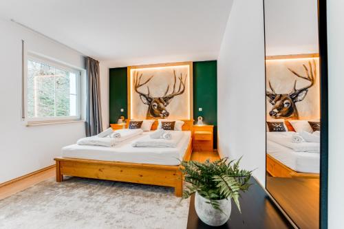 duas camas num quarto com cabeças de veado na parede em VYLD: Bad Hindelang inmitten der Berge em Bad Hindelang