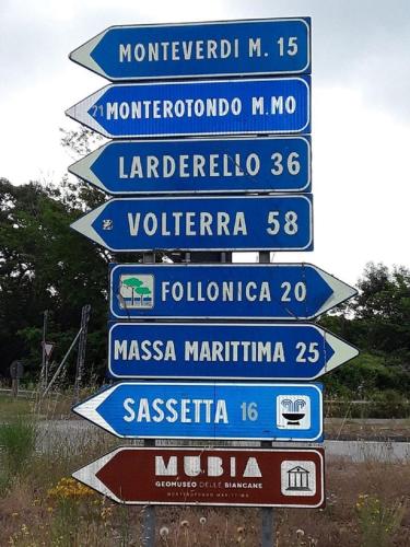 a group of street signs on a pole at Monolocale con bagno, angolo cottura e letto matrimoniale a Baldacchino in Monterotondo
