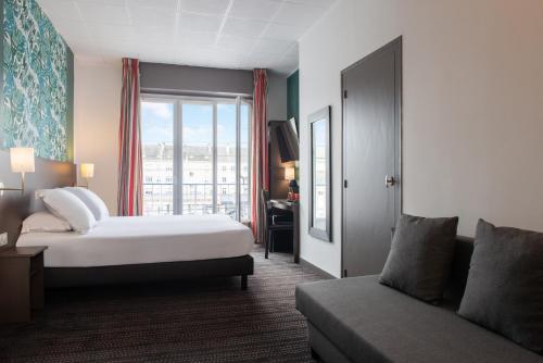 サン・ナゼールにあるThe Originals City, Hôtel de l'Europe, Saint-Nazaireのベッドとソファのあるホテルの部屋