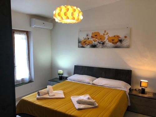 Un dormitorio con una cama amarilla con toallas. en Villa Verde, en Badesi