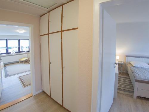a room with a closet and a bedroom with a bed at Ferienwohnung Unter den Eichen, FeWo Vermittlung Nordsee in Varel