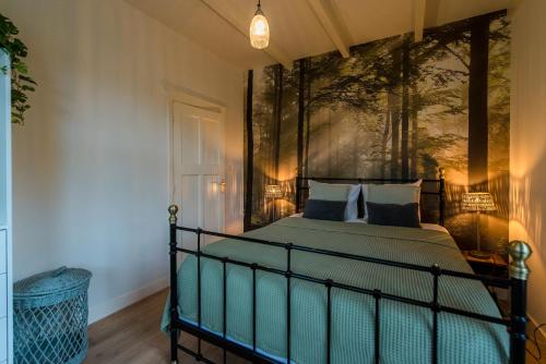 a bedroom with a bed with a painting on the wall at De Klokkenluider in Hollum