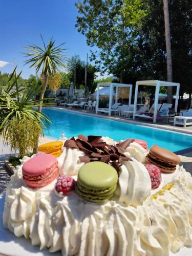 a cake with cookies and whipped cream next to a pool at Biancopineta in Marina di Montenero