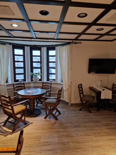 um quarto com uma mesa e cadeiras e uma televisão em Hotel Meeresfriede em Cuxhaven