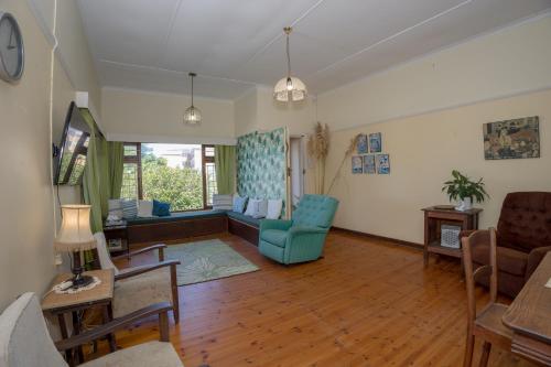 a living room with blue chairs and a couch at Sea Breeze Stay in East London