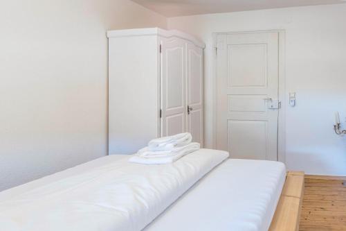a white bedroom with a bed with towels on it at Haus Steinatal in Ühlingen-Birkendorf