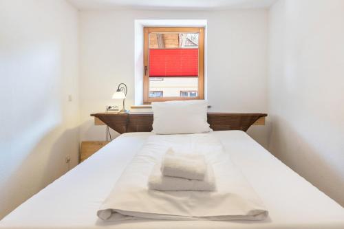 a white bed with two pillows and a window at Haus Steinatal in Ühlingen-Birkendorf