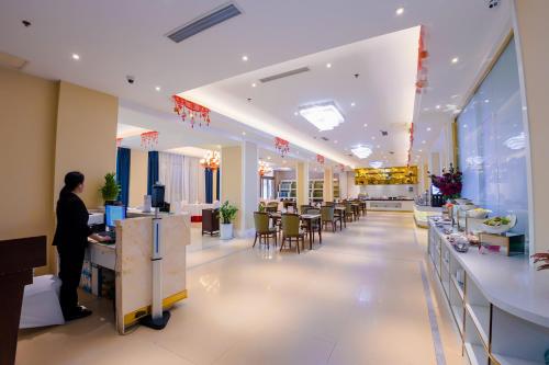 a person standing at a counter in a store at Continental Xin Hao Hotel and Resort 洲际新濠酒店 in Sihanoukville