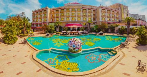a hotel with a large pool in front of a building at Continental Xin Hao Hotel and Resort 洲际新濠酒店 in Sihanoukville
