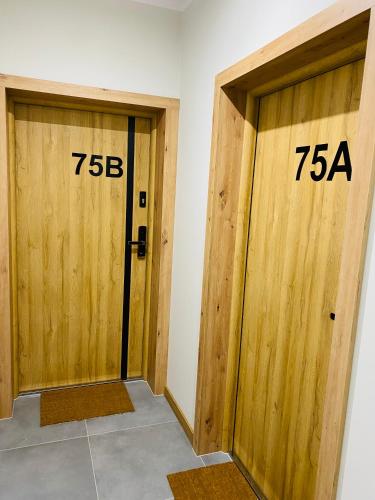 two wooden doors with numbers on them in a room at Apartamenty Białe nad jeziorem Białym in Augustów
