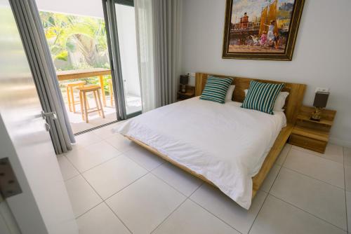 a bed in a room with a window at The Spot with LOV in Grand Baie