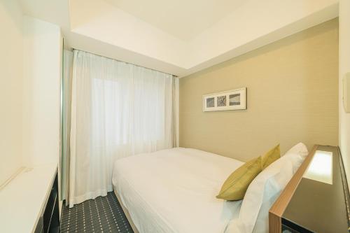 Postel nebo postele na pokoji v ubytování Kanda Station Hotel