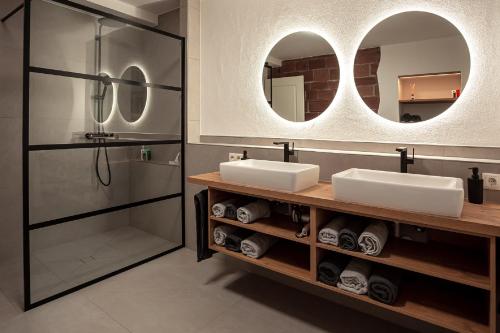 un bagno con 2 lavandini, doccia e specchi di Ferienwohnungen - Gutshof Dürrhof 