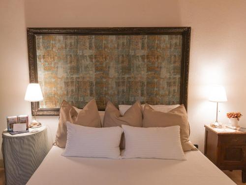 a bedroom with a large bed with white pillows at Agriturismo Borgo di Campagna Il Tesoro in Torre Alfina