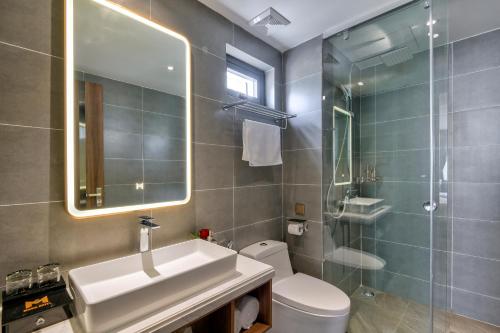 a bathroom with a sink and a toilet and a mirror at Maris Hotel Nha Trang in Nha Trang