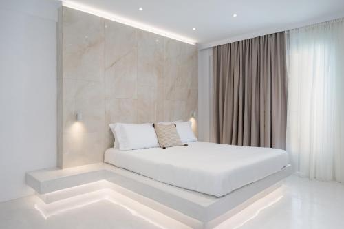 a white bedroom with a white bed in a room at Cycladic Suites & Spa in Fira