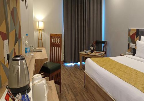 a hotel room with a bed and a desk at Hotel Square One by D'Polo Dharamshala in Dharamshala