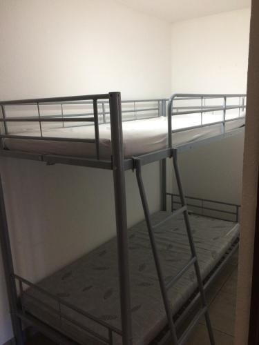 Ce lit superposé se trouve dans une petite chambre dotée de lits superposés. dans l'établissement Appartement charmant Canet-en-Roussillon 36m² piscine partagée, à Canet