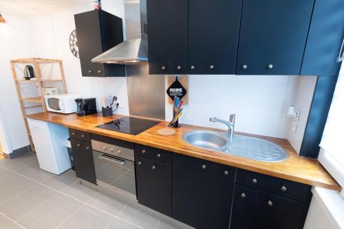 uma cozinha com armários azuis e um lavatório em Joli T2 tout équipé Quartier Piéton par Groom* em Lorient